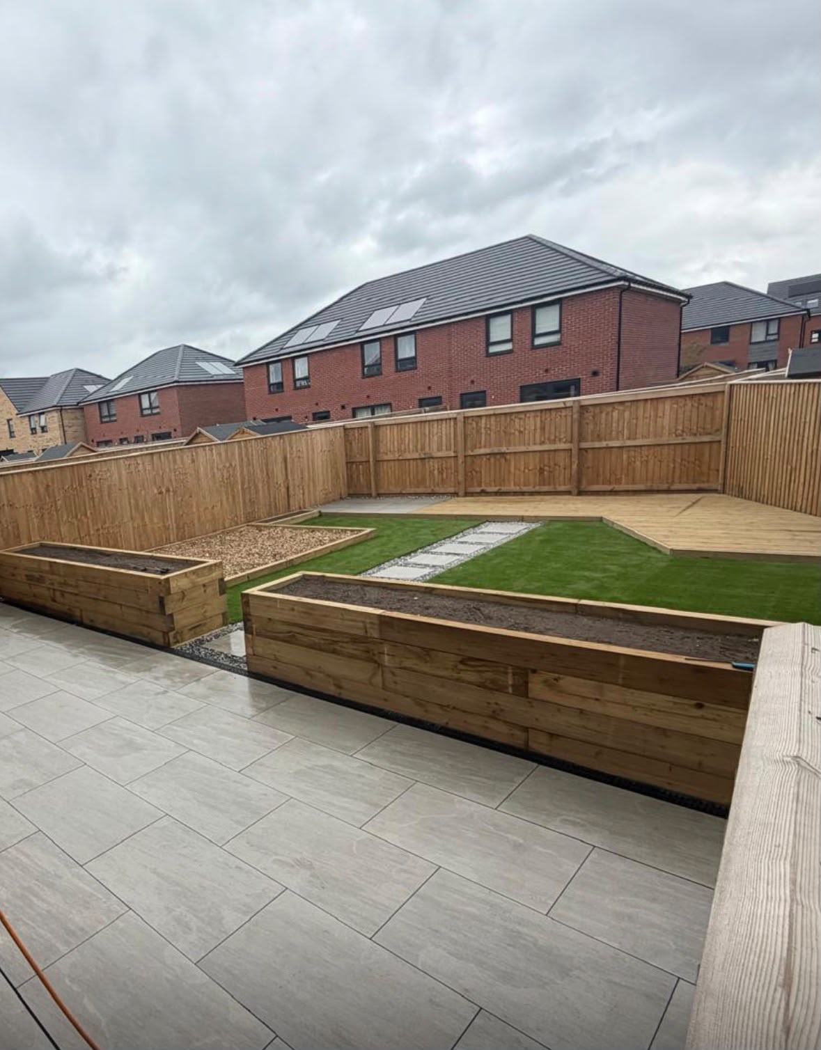 Timber raised planters, bark play square, lawn and decking
